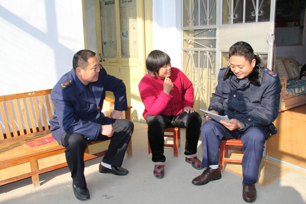 执法人员面对面对群众进行防传销宣传教育